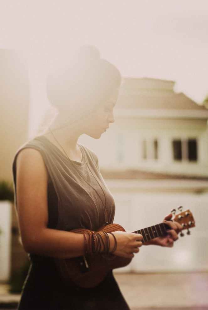 woman in brown sleeveless dress while playing ukulele