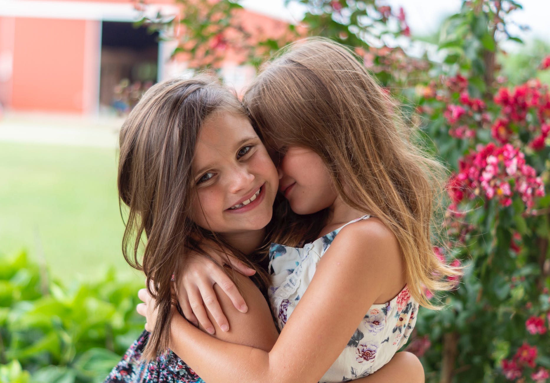 close up photo of two little girls hugging each other